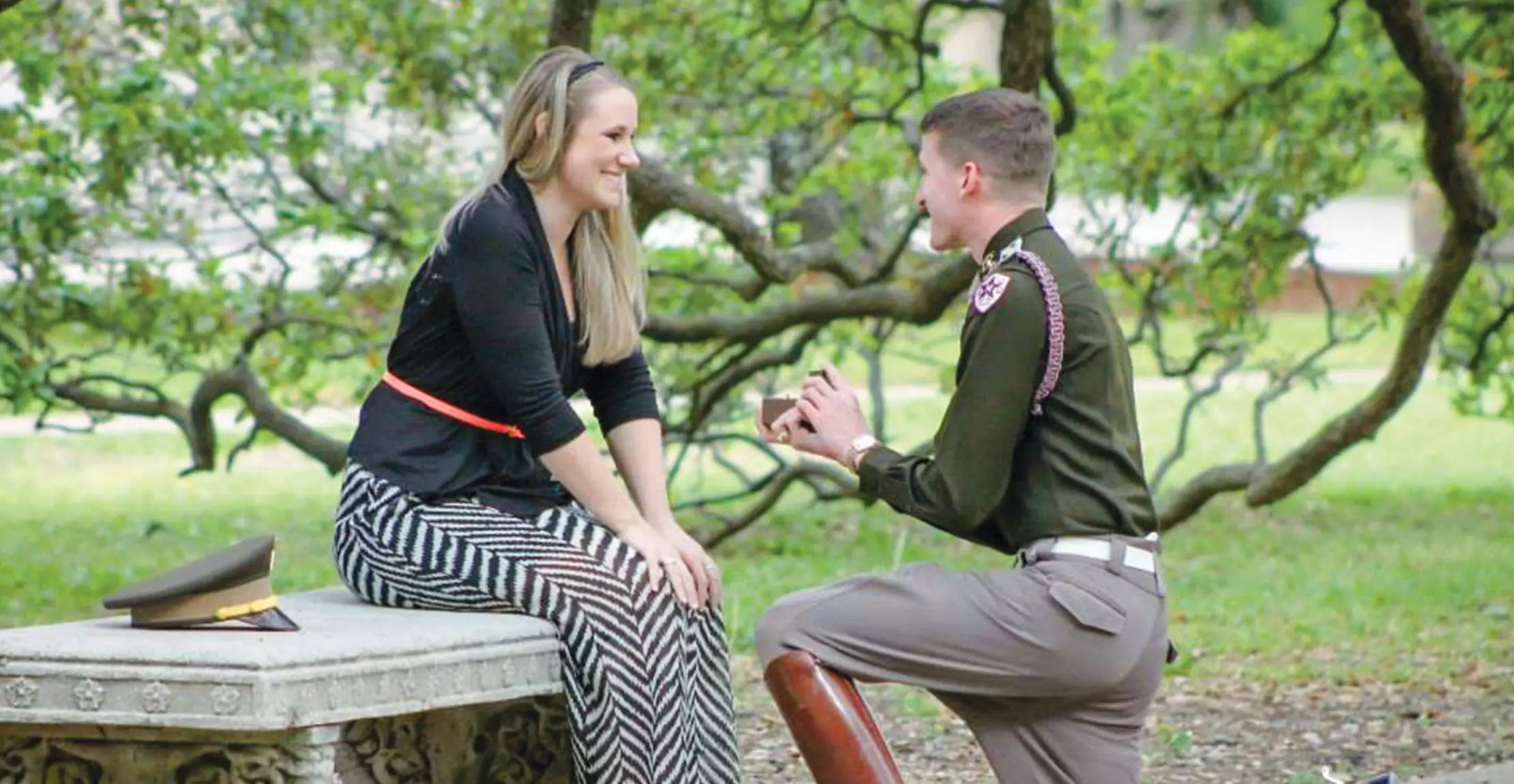 A man proposes to a woman in a park