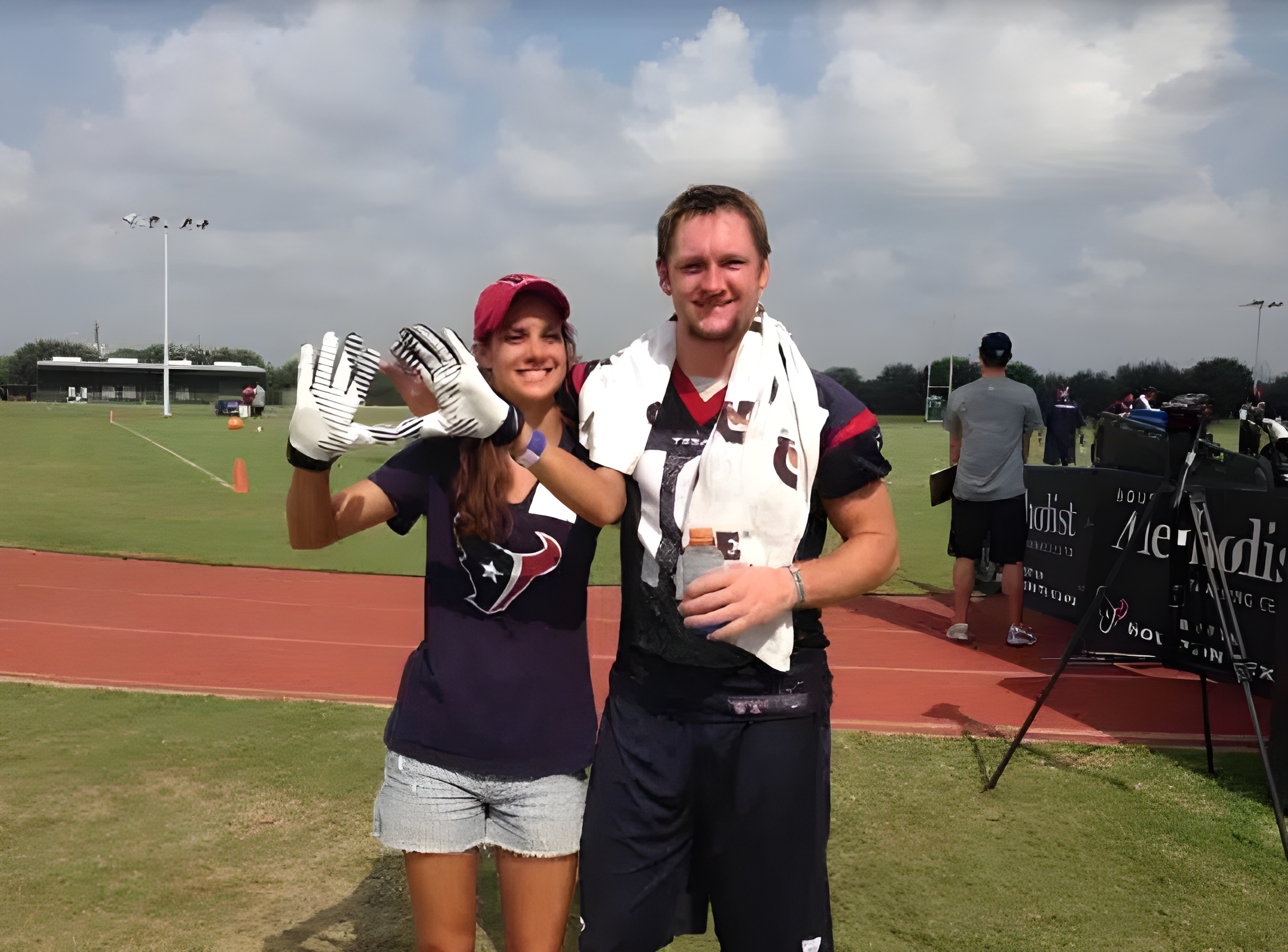 A man and woman pose in football uniforms