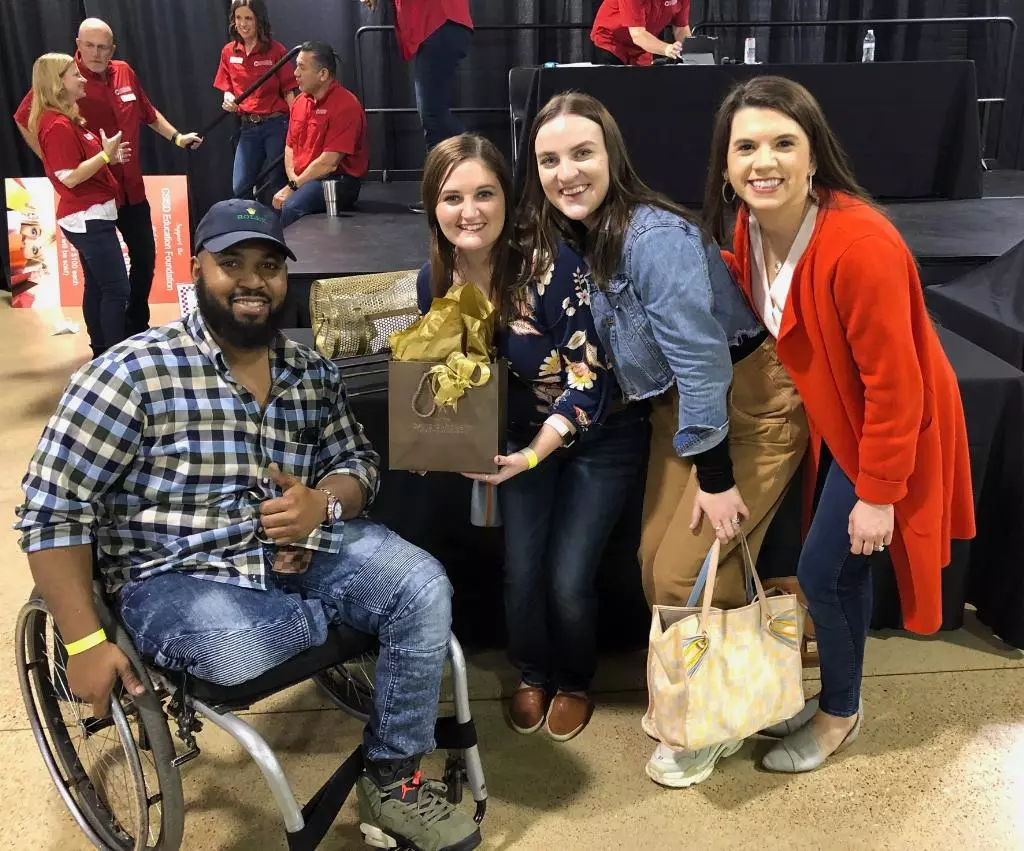 Steve Duncan poses with three women holding gift bags