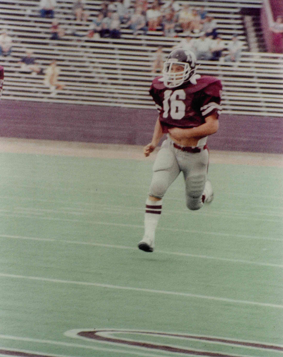 James Barret running on a football field during a game