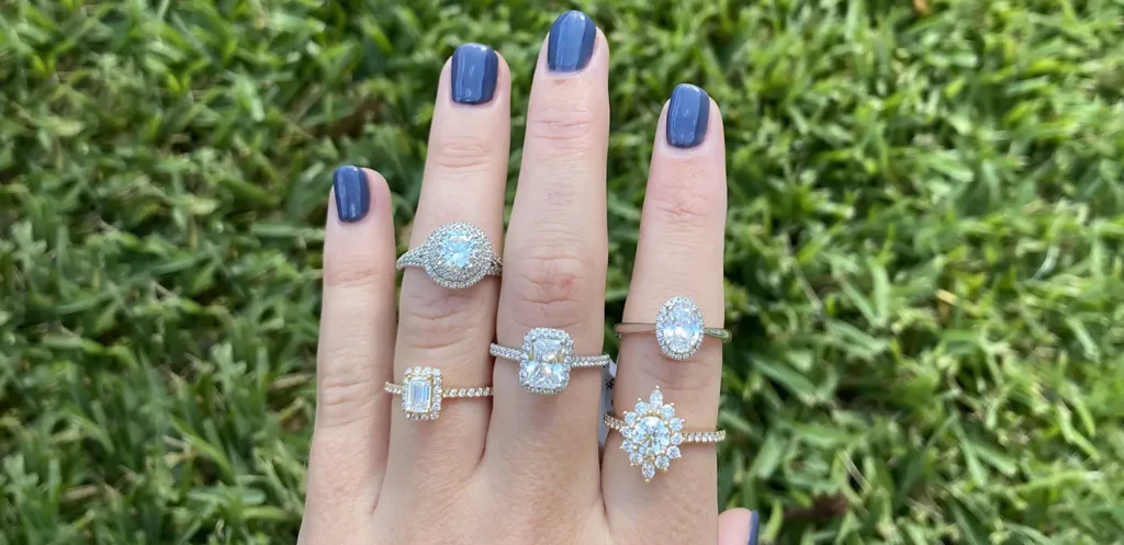 Variety of Halo engagement rings on fingers in varying sizes and styles