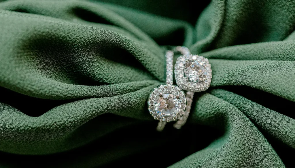 a halo engagement rings on green fabric
