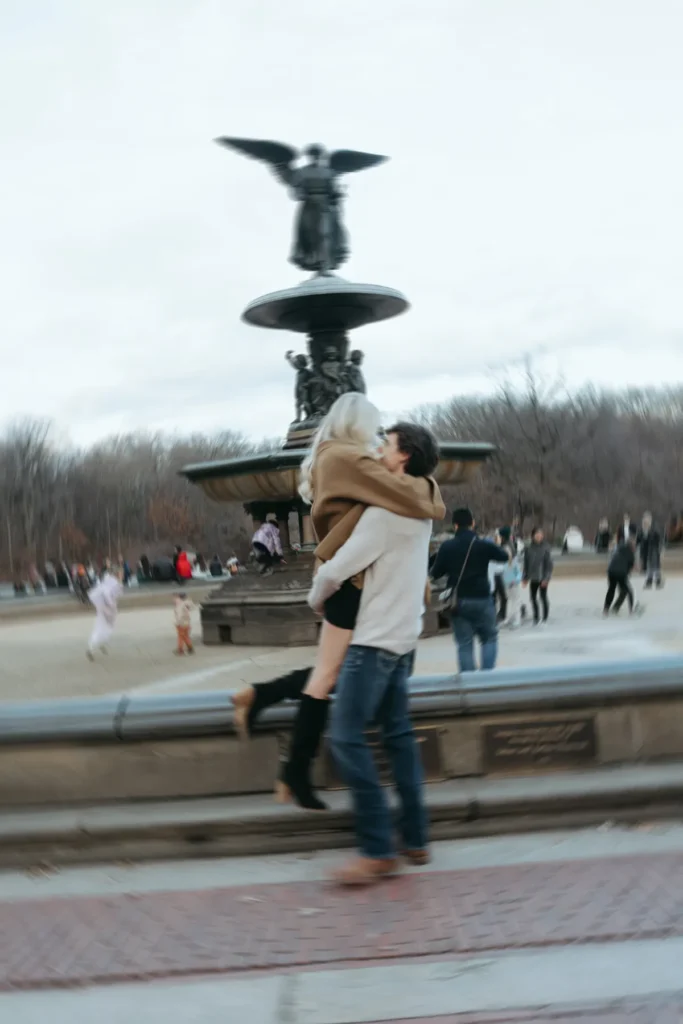 Haley and Jacob embracing in central park with their custom diamond engagement ring by David Gardner's 