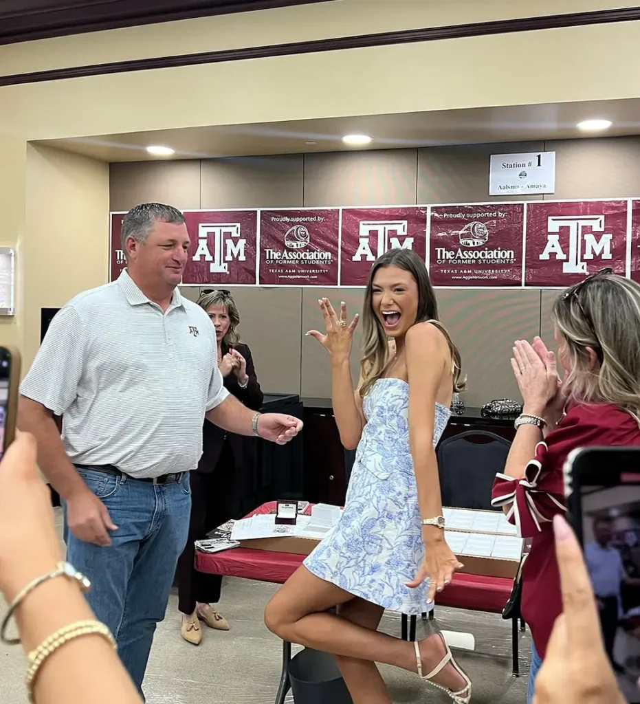 Aggie Graduate smiling with family member and her class ring and RW Fine RingWrap