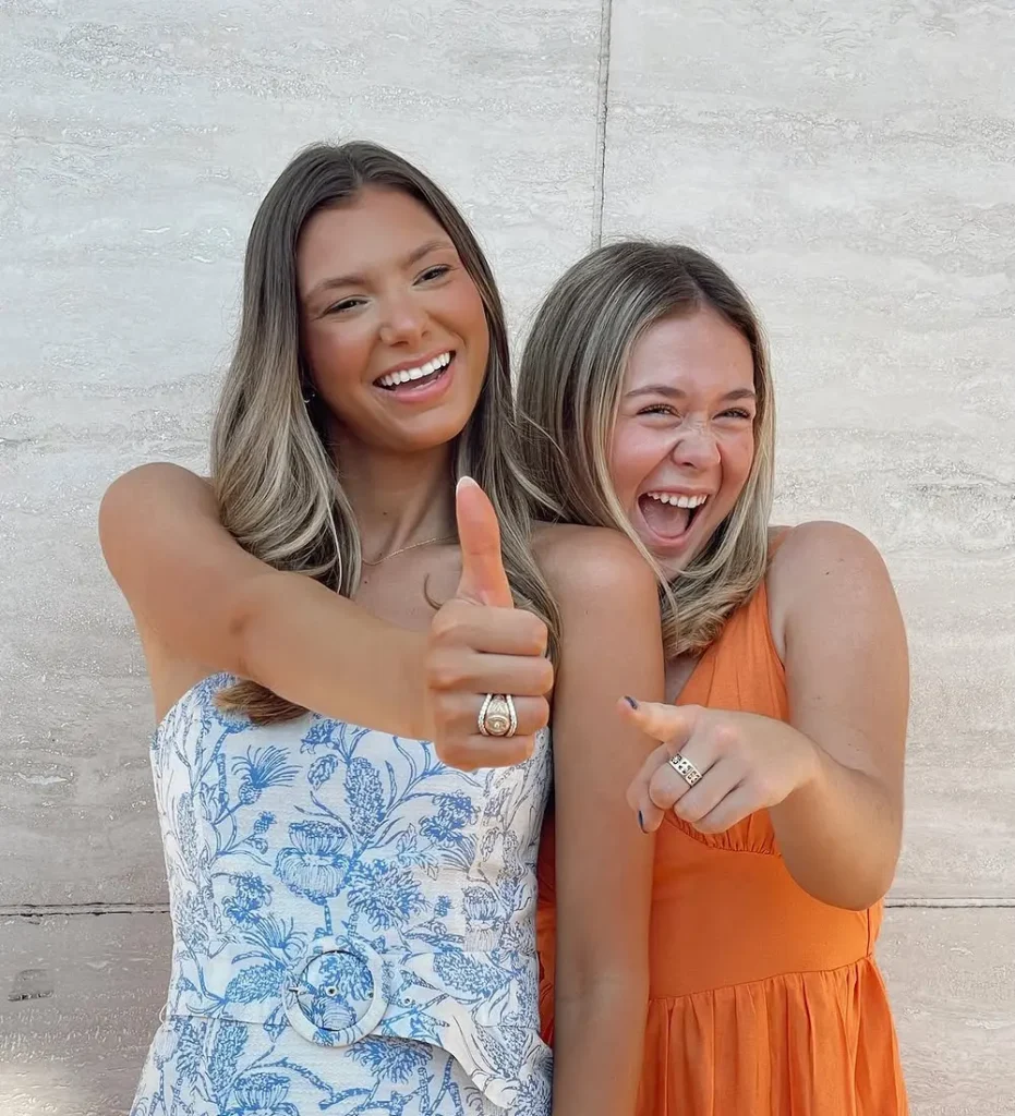 Aggie Graduate smiling with friend and her class ring and RW Fine RingWrap